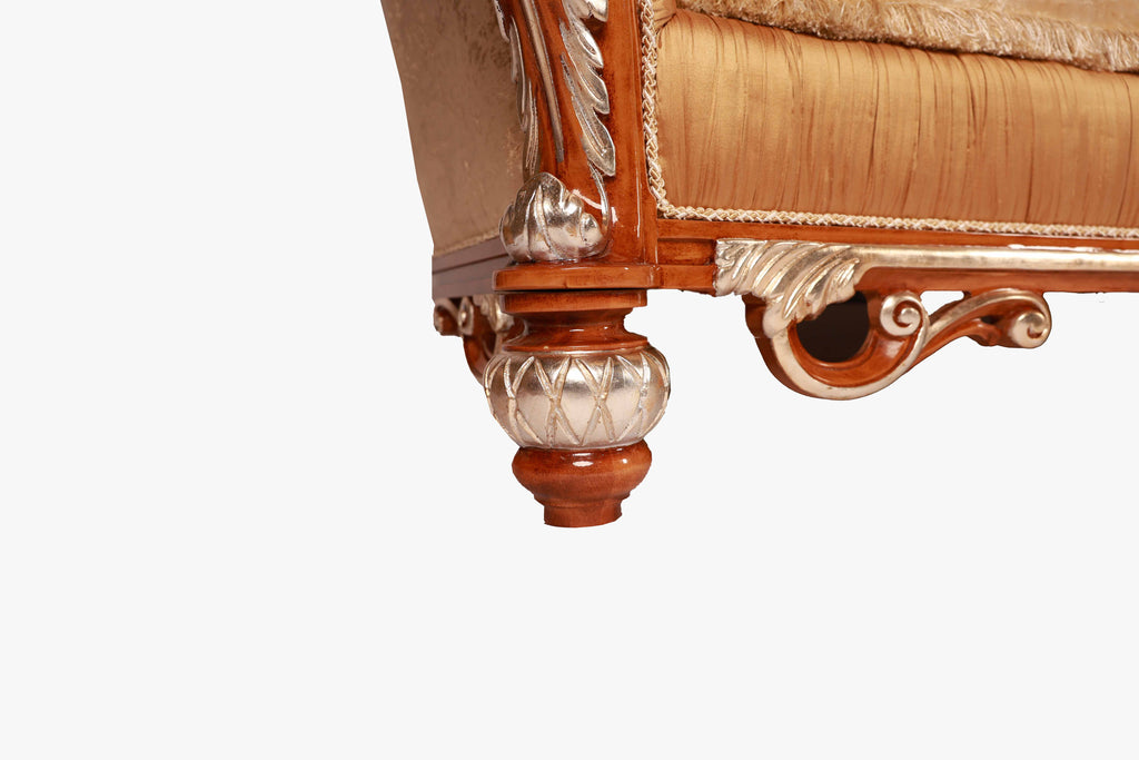 Close-up of a decorative armchair with intricate woodwork and fabric.