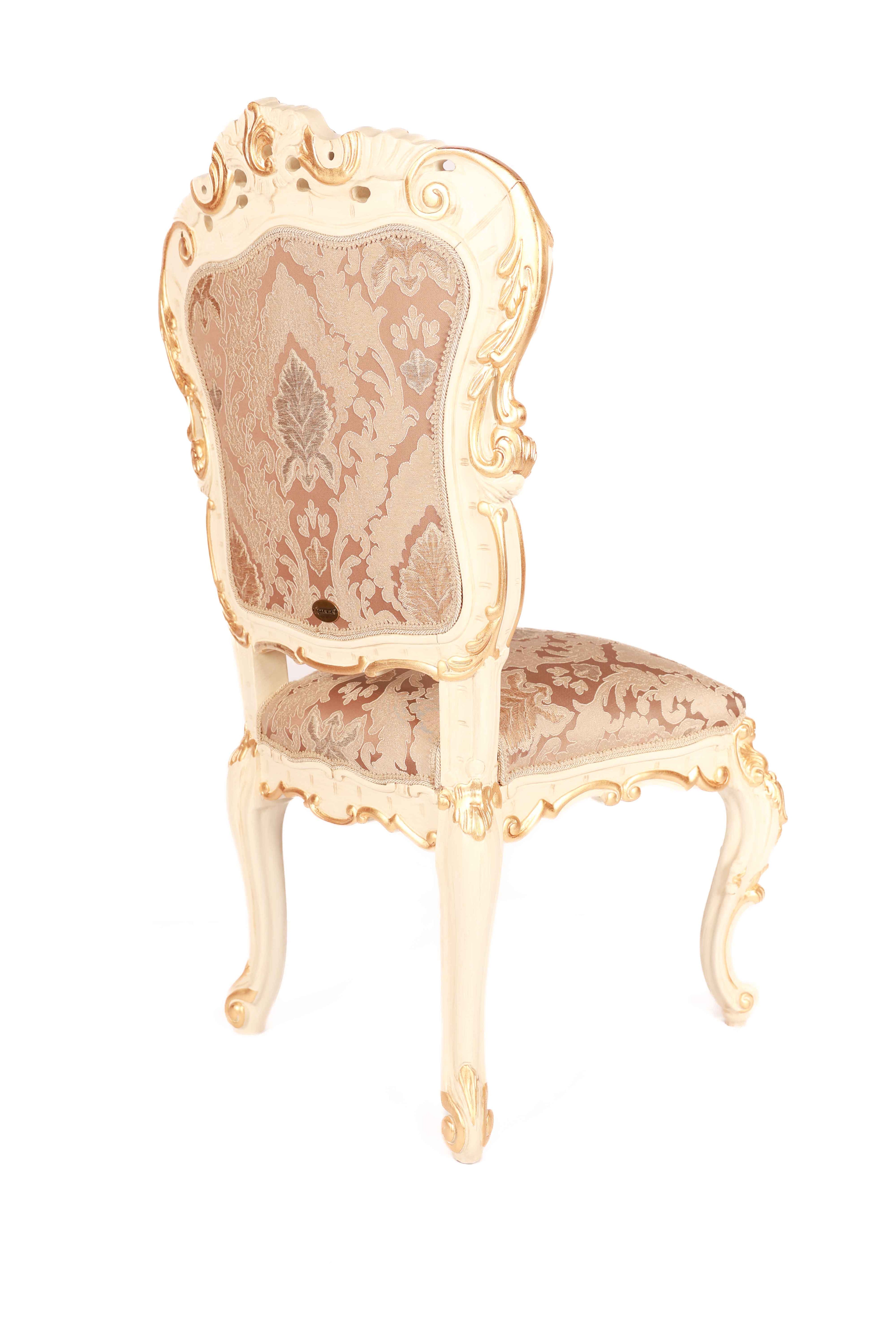 Decorative chair with ornate gold frame and pink floral patterned seat 
