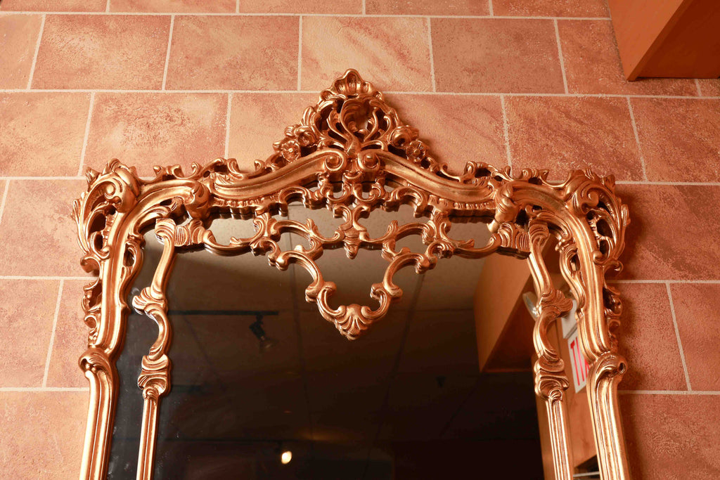 Decorative gold mirror with intricate designs 