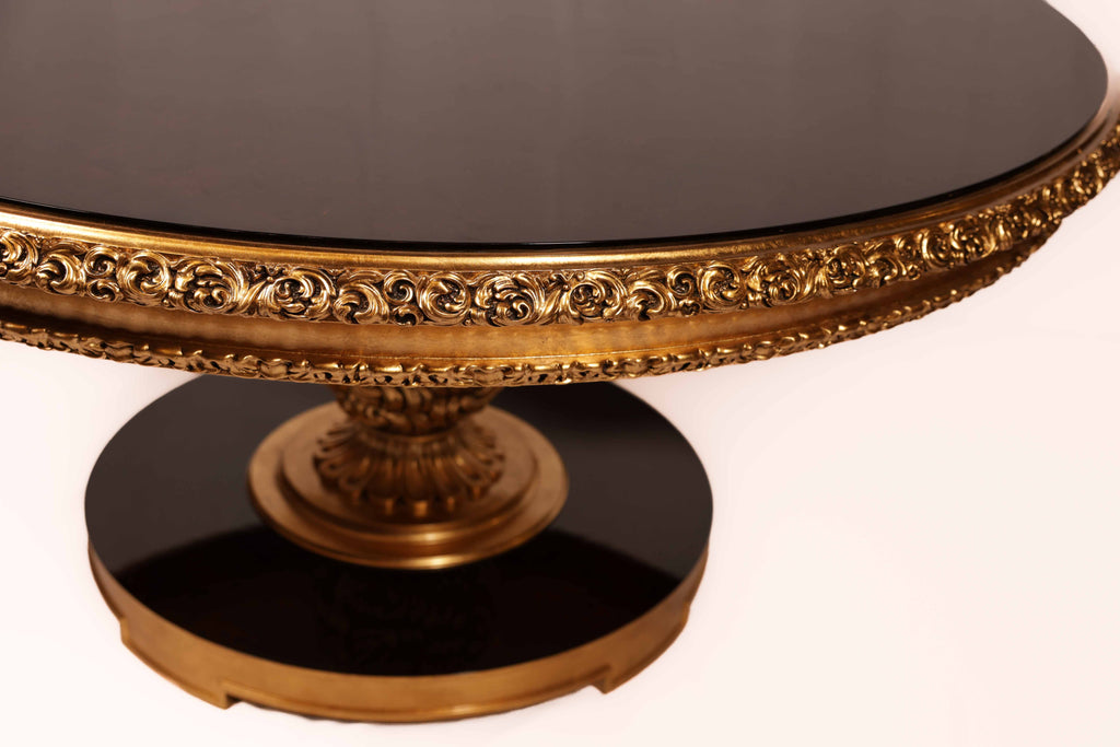 Decorative round table with gold embellishments and black surface 