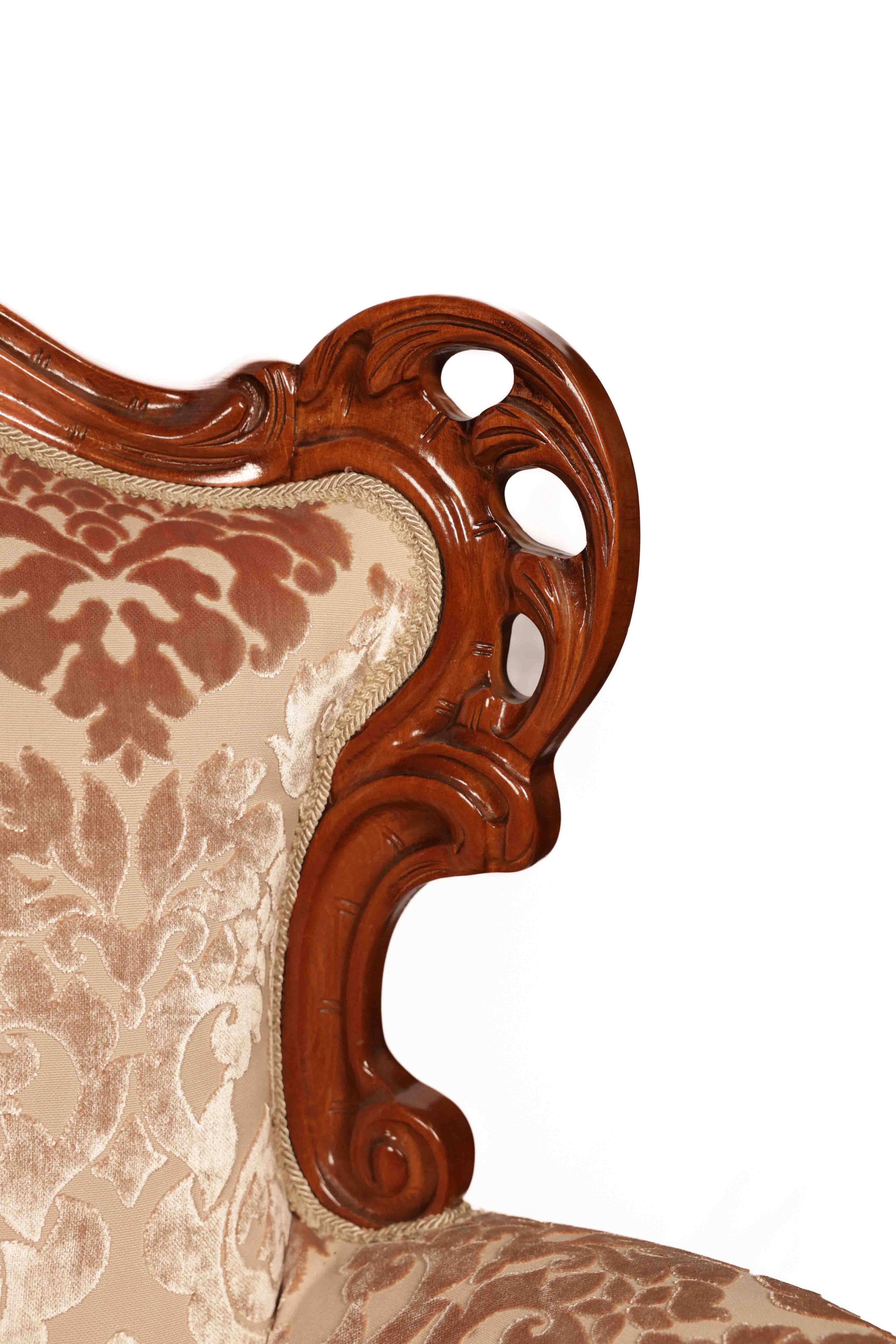 Close-up of an ornate chair with wooden armrest and patterned fabric 